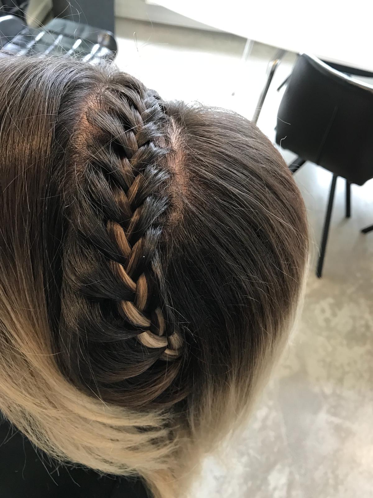 Ingevlochten vlecht over de kruin van donker haar met blonde punten